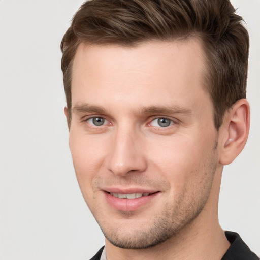 Joyful white young-adult male with short  brown hair and grey eyes