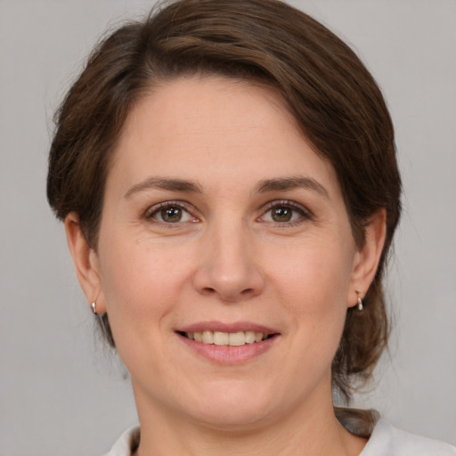 Joyful white adult female with medium  brown hair and grey eyes