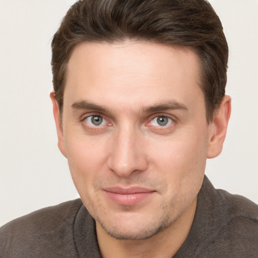 Joyful white young-adult male with short  brown hair and grey eyes