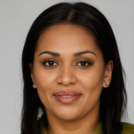 Joyful black young-adult female with long  brown hair and brown eyes