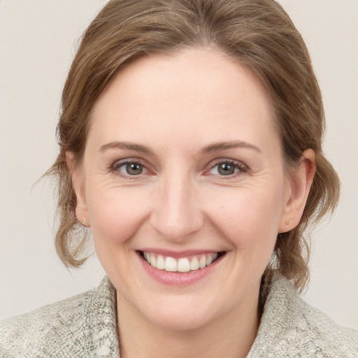 Joyful white young-adult female with medium  brown hair and blue eyes