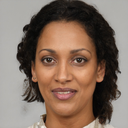 Joyful black adult female with medium  brown hair and brown eyes