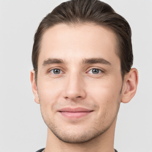 Joyful white young-adult male with short  brown hair and grey eyes