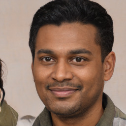 Joyful latino young-adult male with short  black hair and brown eyes