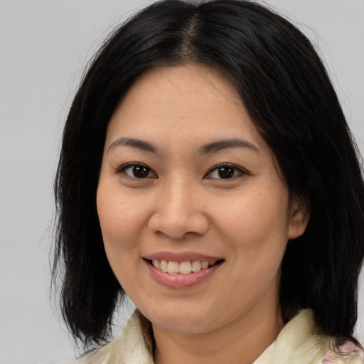 Joyful asian young-adult female with medium  brown hair and brown eyes