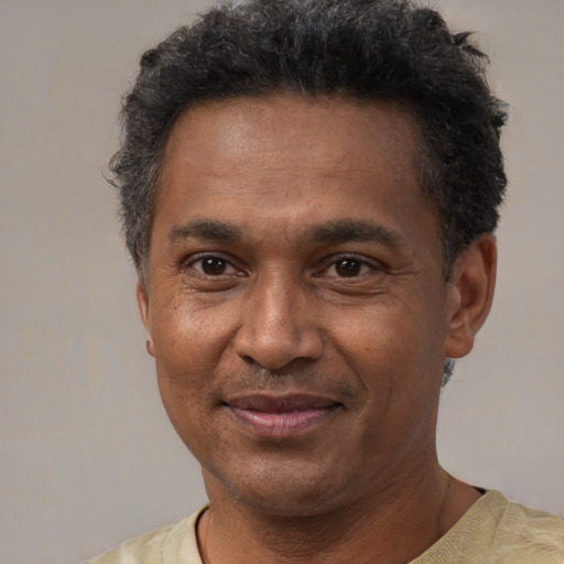 Joyful latino adult male with short  black hair and brown eyes