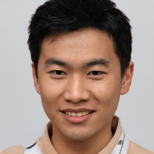 Joyful asian young-adult male with short  black hair and brown eyes
