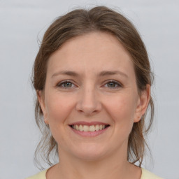 Joyful white young-adult female with medium  brown hair and grey eyes