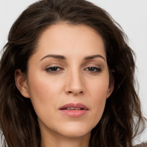 Joyful white young-adult female with long  brown hair and brown eyes