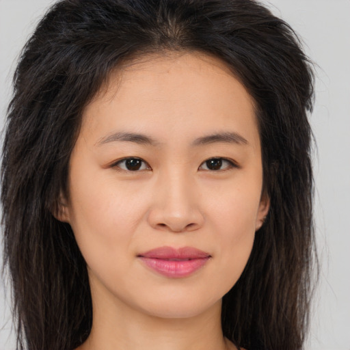 Joyful asian young-adult female with long  brown hair and brown eyes