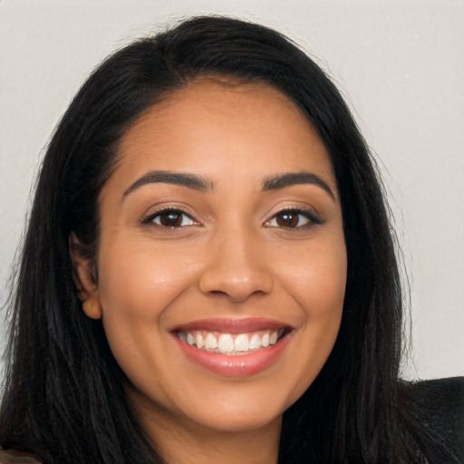 Joyful latino young-adult female with long  black hair and brown eyes