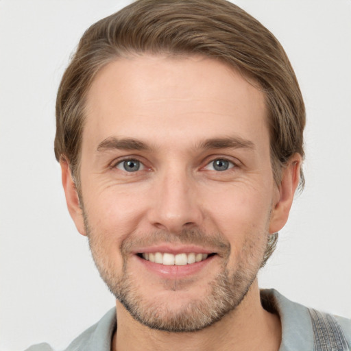 Joyful white young-adult male with short  brown hair and grey eyes