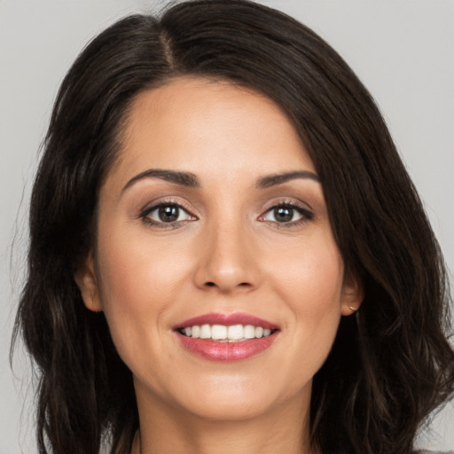 Joyful white young-adult female with long  brown hair and brown eyes