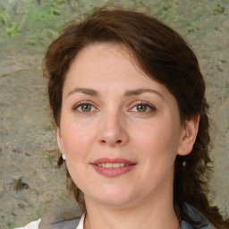 Joyful white young-adult female with medium  brown hair and green eyes