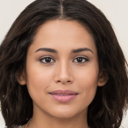 Joyful latino young-adult female with long  brown hair and brown eyes