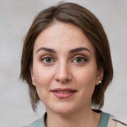 Joyful white young-adult female with medium  brown hair and grey eyes