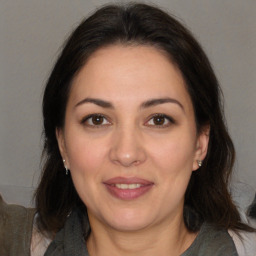 Joyful white adult female with medium  brown hair and brown eyes