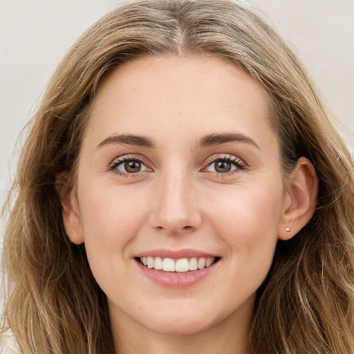 Joyful white young-adult female with long  brown hair and green eyes