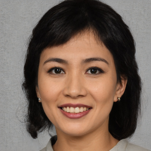 Joyful asian young-adult female with medium  brown hair and brown eyes