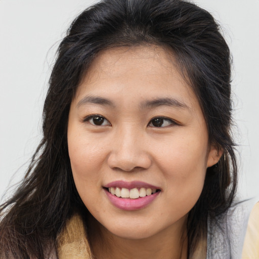 Joyful asian young-adult female with long  brown hair and brown eyes