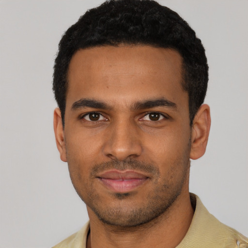 Joyful black young-adult male with short  black hair and brown eyes