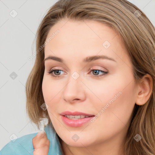 Joyful white young-adult female with long  brown hair and blue eyes