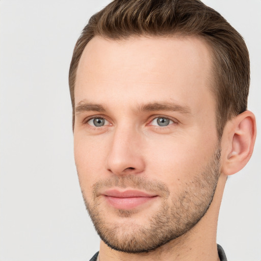 Joyful white young-adult male with short  brown hair and grey eyes