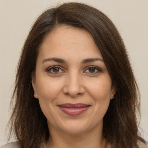 Joyful white adult female with long  brown hair and brown eyes