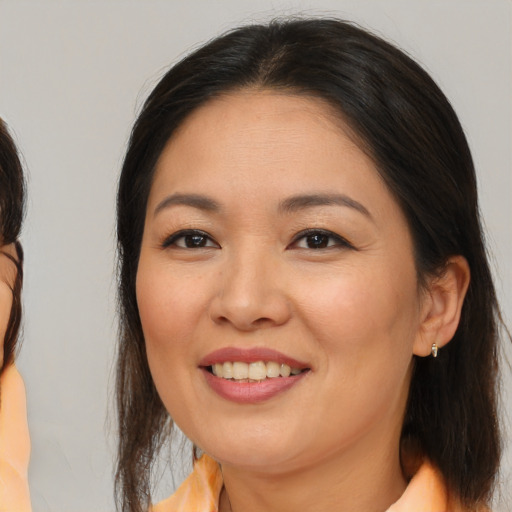 Joyful asian adult female with medium  brown hair and brown eyes