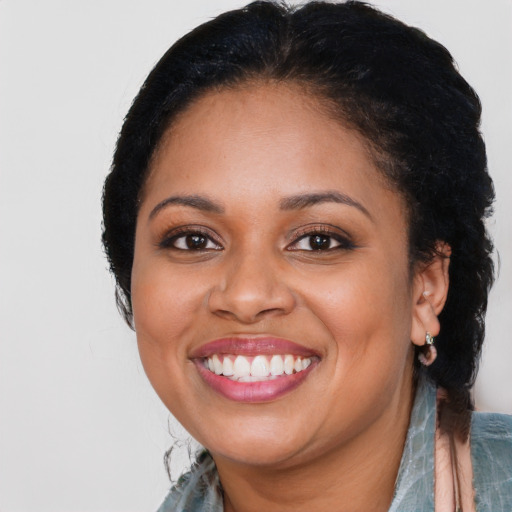 Joyful black young-adult female with short  black hair and brown eyes