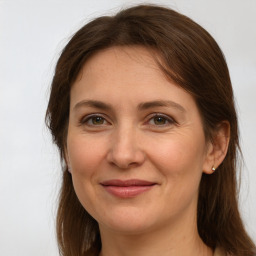 Joyful white adult female with long  brown hair and grey eyes