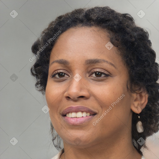 Joyful black adult female with long  brown hair and brown eyes