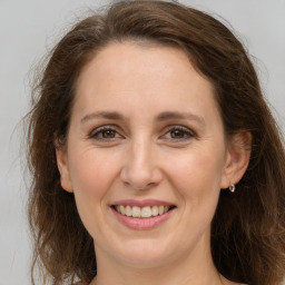 Joyful white adult female with long  brown hair and grey eyes