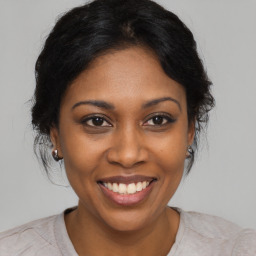 Joyful black young-adult female with medium  brown hair and brown eyes