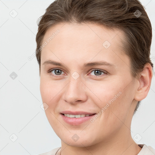 Joyful white young-adult female with short  brown hair and grey eyes