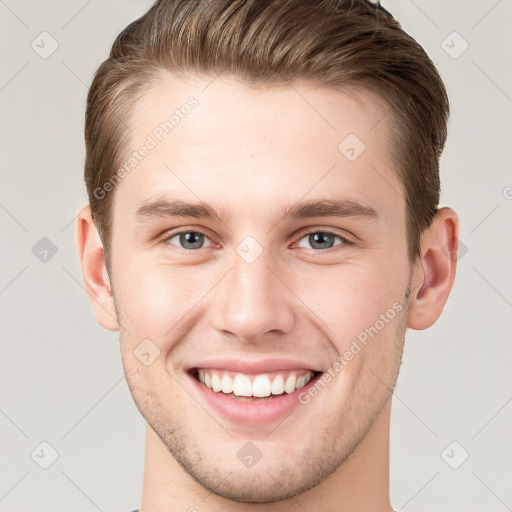 Joyful white young-adult male with short  brown hair and grey eyes