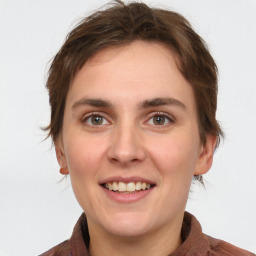 Joyful white young-adult female with medium  brown hair and grey eyes