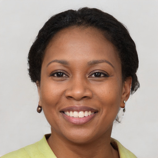 Joyful black young-adult female with short  brown hair and brown eyes