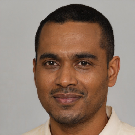 Joyful black young-adult male with short  black hair and brown eyes