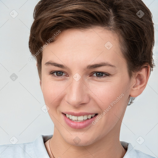 Joyful white young-adult female with short  brown hair and grey eyes