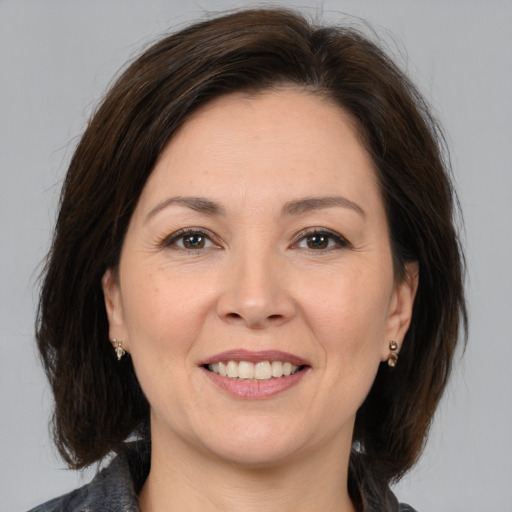 Joyful white adult female with medium  brown hair and brown eyes