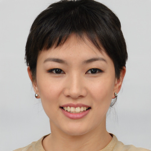 Joyful asian young-adult female with short  brown hair and brown eyes