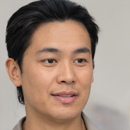 Joyful asian young-adult male with short  brown hair and brown eyes