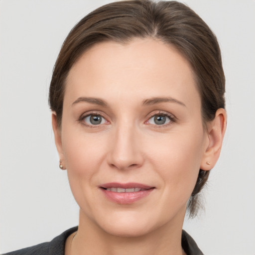 Joyful white young-adult female with medium  brown hair and grey eyes