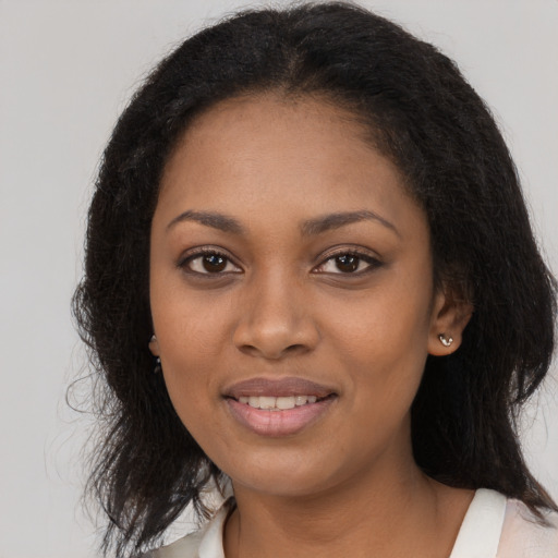 Joyful black young-adult female with long  black hair and brown eyes