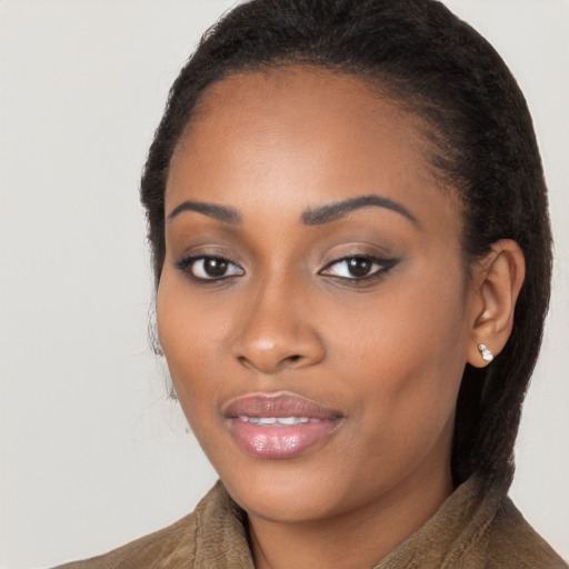 Joyful black young-adult female with long  brown hair and brown eyes