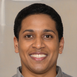 Joyful latino young-adult male with short  black hair and brown eyes