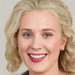 Joyful white young-adult female with long  blond hair and blue eyes