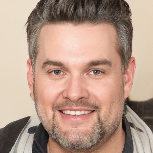 Joyful white adult male with short  brown hair and brown eyes