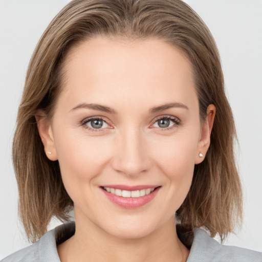 Joyful white young-adult female with medium  brown hair and grey eyes